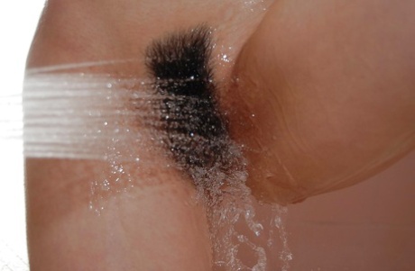 Asian teen taking shower and teasing her hairy slit with shower jets