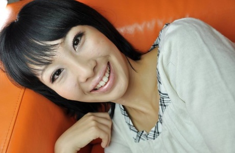Smiley asian MILF takes off her panties and enjoys sex toys play