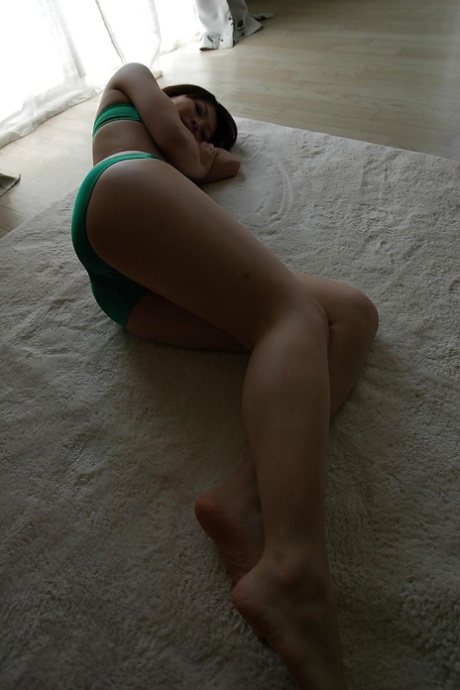 On the sofa, Maki Yoshikawa is seen undressing and posing in the nude.