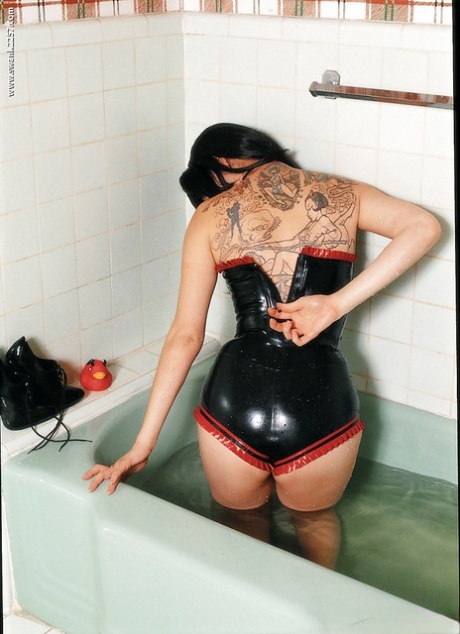 A cuddly asian female slips from her sensual latex attire in the bathroom.