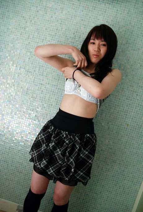 In a close-up shot, Kasumi Minasawa is seen undressing and spreading her lips.