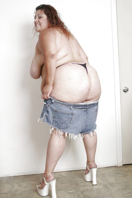 Undressed and spreading her lips on her leg, this is a huge Latina woman in jeans shorts with an extra size.