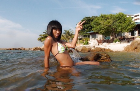 The beautiful Noon in Thai poses on the beach before giving a hard blowjob.