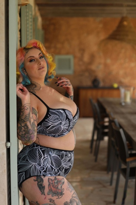 Fatty-colored model with colorful hair and a tattoo, Galda Lou, stripped down before posing naked.