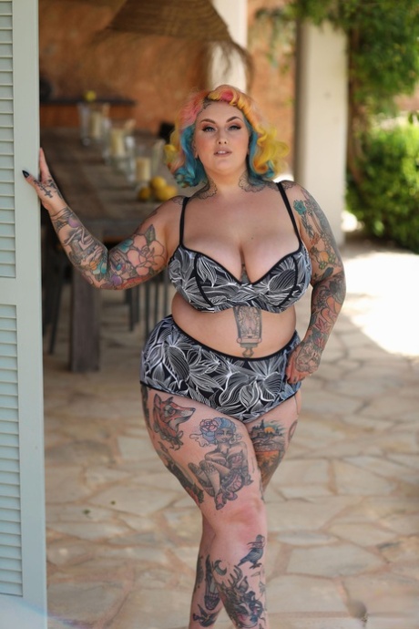 An inked model with vibrant hairstyle, Fatty GALADE and a nude pose is depicted by Galdas Lou.