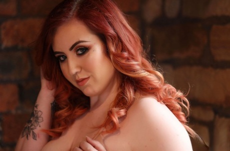 Fatty redhead model Freyja reveals her tits while posing in her sexy lingerie