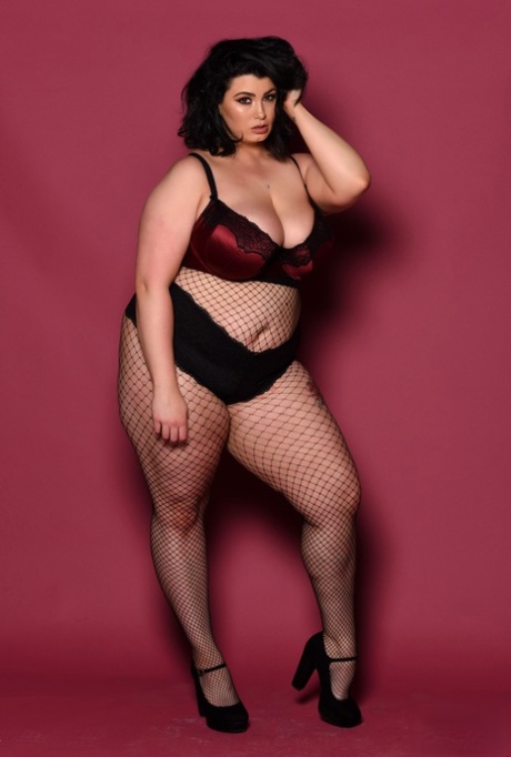 Kiki, the full-figured babe, displays her saggy tits while wearing body stockings.