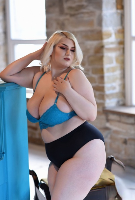 Big tits: Peaches, a chubby blonde model, strips off her blue bra and shows off her giant tits.