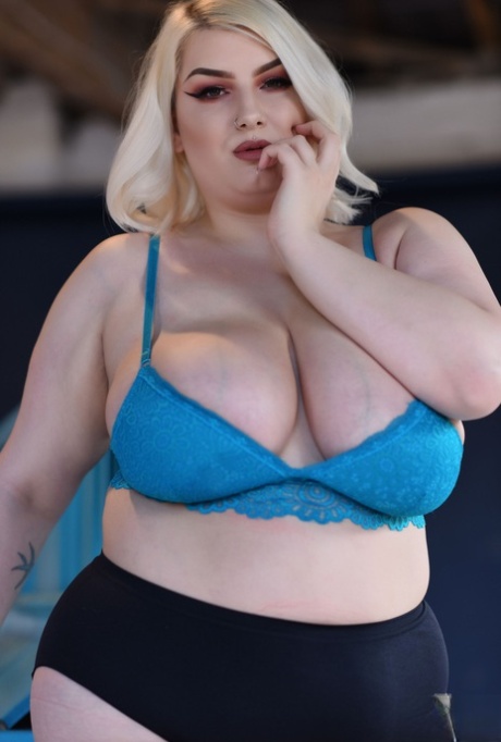 Model Peaches, who is fat and blonde bares her blue bra while showing off giant tits.