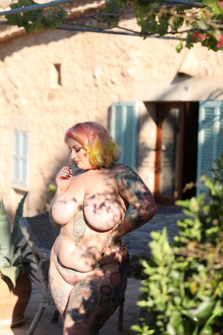 Outside, BBW Galda Lou is seen with her massive natural breasts and well-defined abs, having been tattooed.