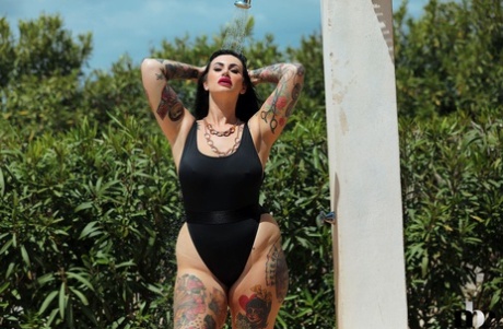 A tattooed babé known as Chubby, Cherrie Pie, takes off in her swimsuit while showering outside.