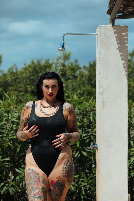 Chubby's tattooed babe, Cherrie Pie, takes on a swimsuit and stands up while showering outside.