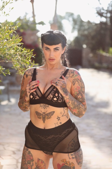 Cherrie Pie, a model with tattoos, displays her massive buttocks and big thighs.