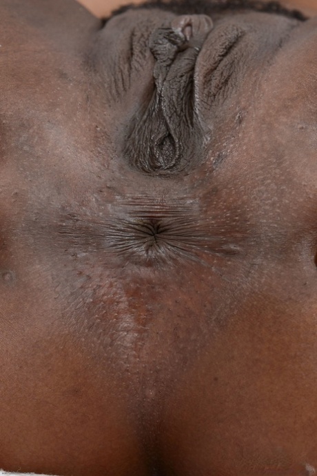 An attractive American ebony named Charlie Rae displays her hairless vagina and buttocks in a close-up shot.