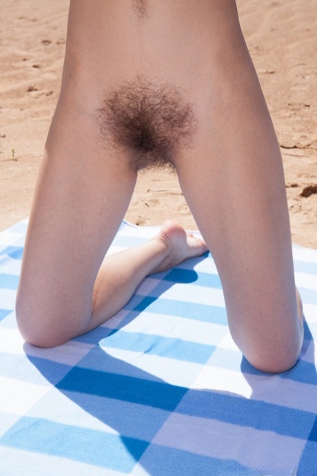 The hairy brunette with full-figured lips, Cleo Dream undresses and masturbates at the beach.