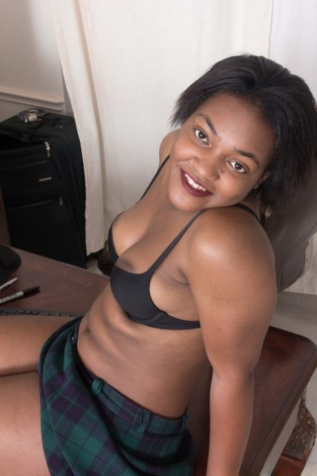 The hairy muff of black amateur Bobbie Rains is displayed on a table as she poses without clothes.