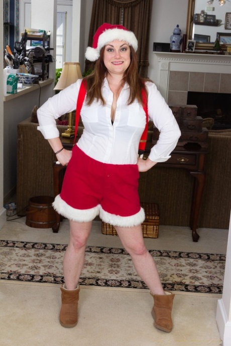 Annatasia Holland removes her Christmas attire and displays her large tits, hairy legs, and crotch.