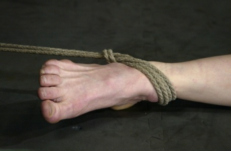 With curly hair, Sye Rena is subjected to whipping and percussion punishment while being punished with a vibrator in rope bondage.