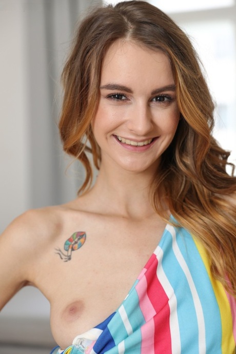 Rudolphin Adelle stripping and exhibiting her hot tattoos, with innocent holes visible in the background.