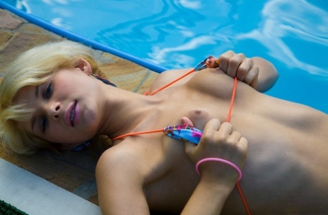 Teenager Lolly playing with her friends in a bikini and flaunting her little tits by the pool.