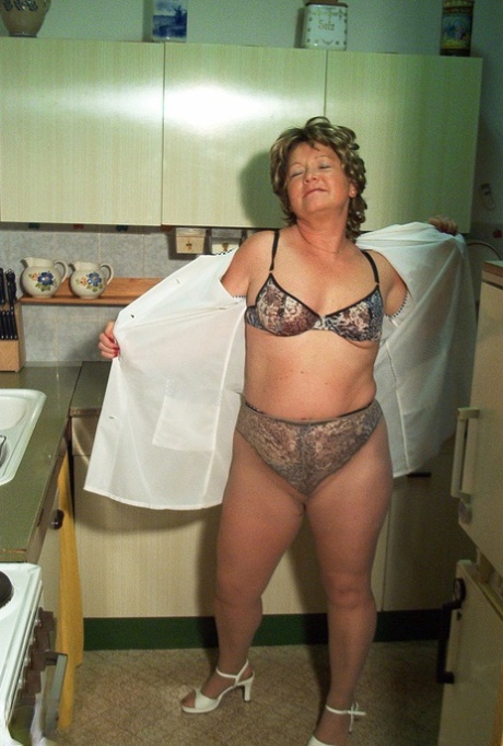 Smaller granny Rita removes her clothing and nylons while masturbating in the kitchen.