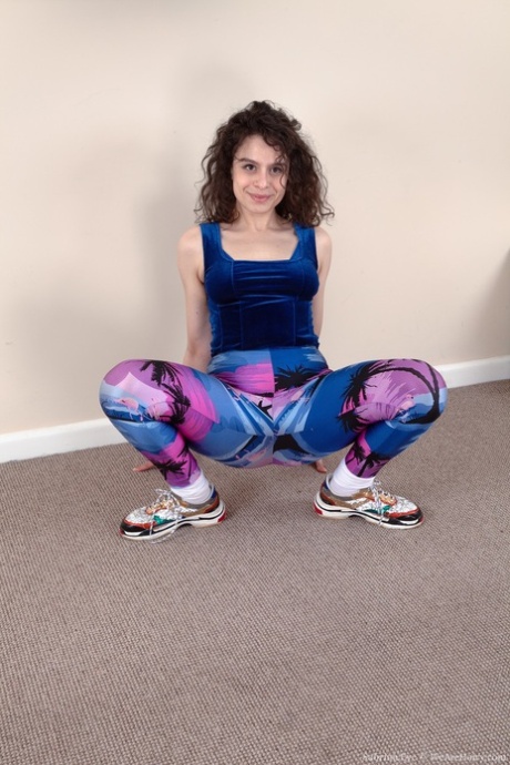 The curly-haired delight, Sabrina Eve, exposes her hairy pussy while wearing leggings.