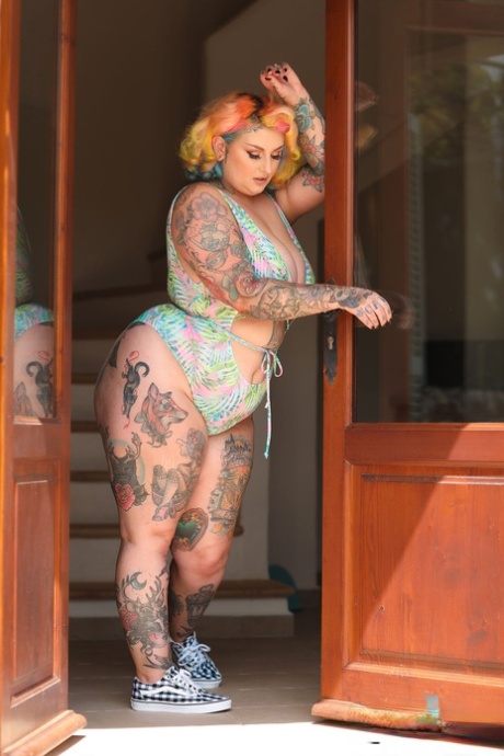 Galda Lou, a pinup fatty, flaunts her massive bum and breasts in a doorway.