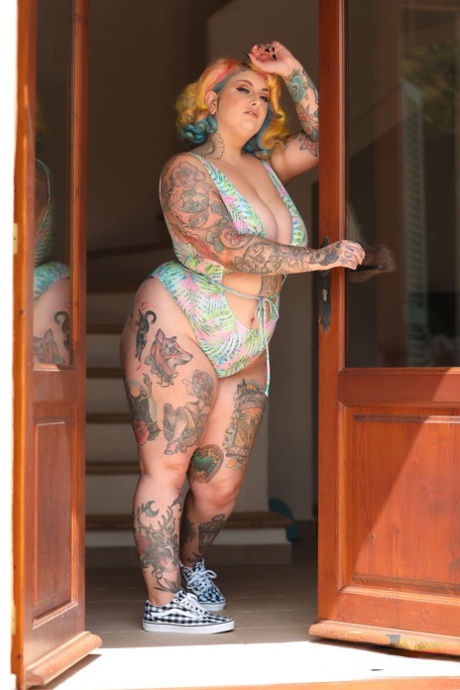 Galda Lou, the hot-headed pinup fatty, flaunts her massive bum and breasts in a doorway.