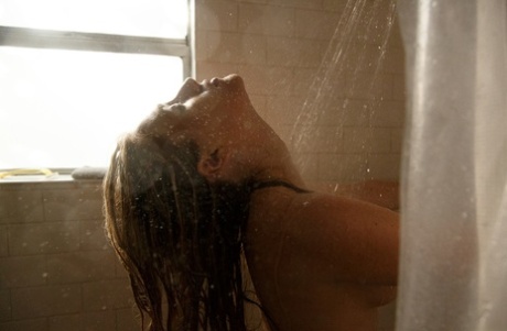 Medium-sized tits: White girl Ember Volland shows off her white legs in the shower.