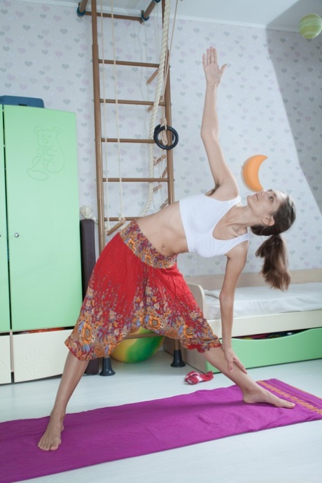 Naked yoga enthusiast Shivali exposes herself to her hairdo as she exercises.