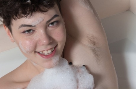 Naked: Chubby Dmitri Vosche poses in the bathtub with her hairy moustache on display.