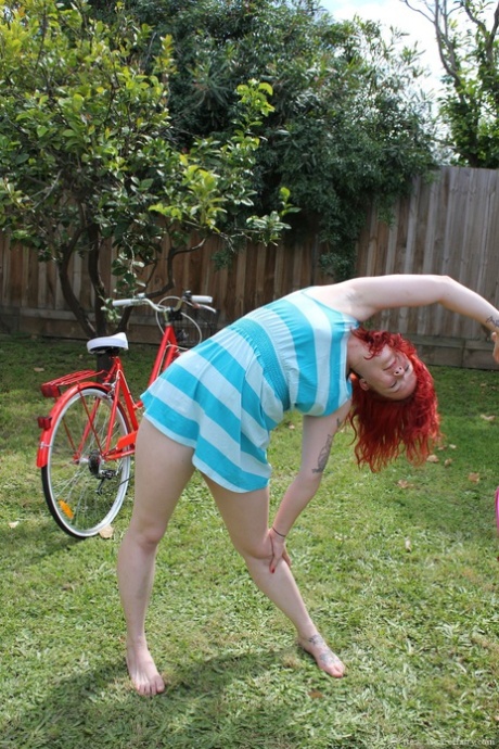 Jette, a naked and inked-out ginger, displays bushy cunts while exercising.
