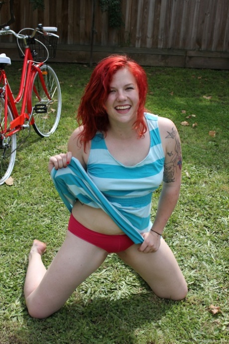 Ginger Jette, with an inked appearance and a tattoo, exercises while showing off her bushy cunts.
