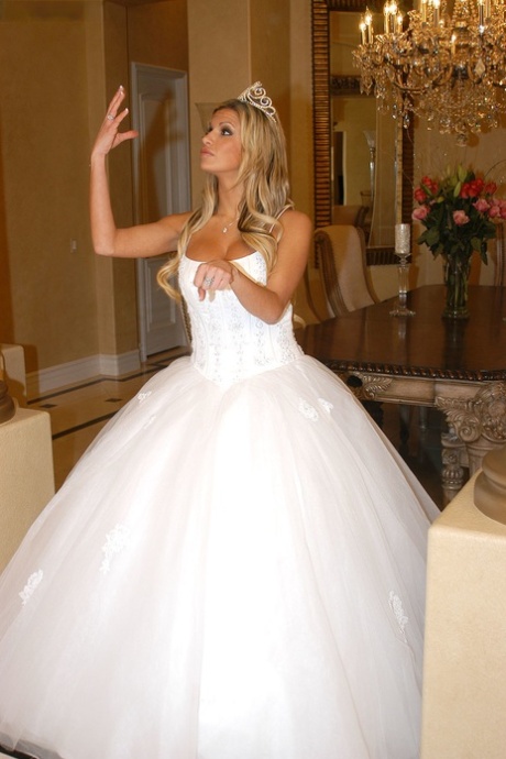 Stunning blonde Kendall Brooks in a wedding dress strips and poses on a couch - PornHugo.net