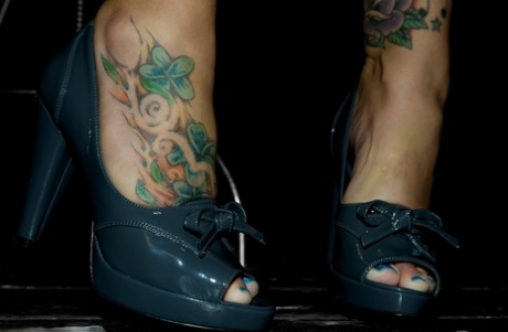 MILF Claire Dames displays her inked feet and unkempt cleavage as she flirts with the camera.