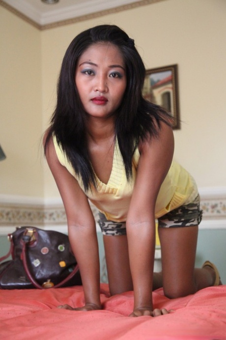 While wearing a yellow shirt, Venice, an Asian amateur girl, exposes her hairy cuntie.