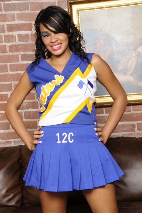 The smiley ebony cheerleader Nyla Danae changes her attire to showcase large natural tits.