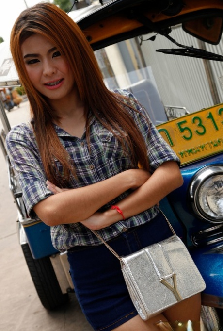 A Thai woman who is naked, has her legs undone and a pretty face models a non-nude image wearing shorts.