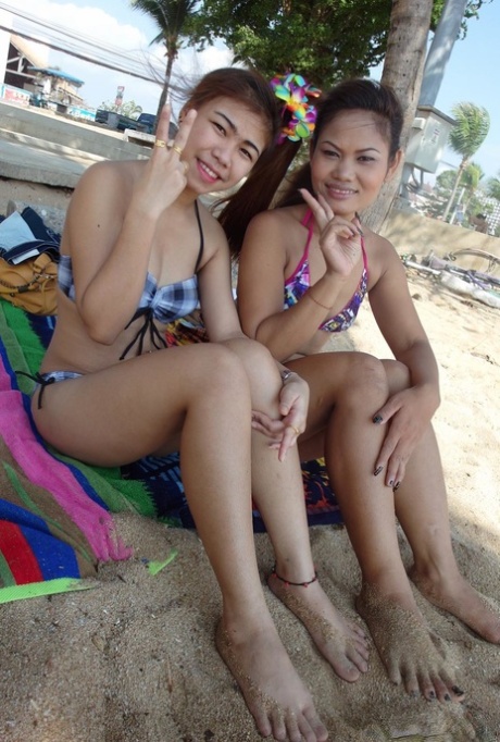 Sweet teenage Thai babes, Bee and Miaw pose for pictures at the beach in their sunniest bikinis.