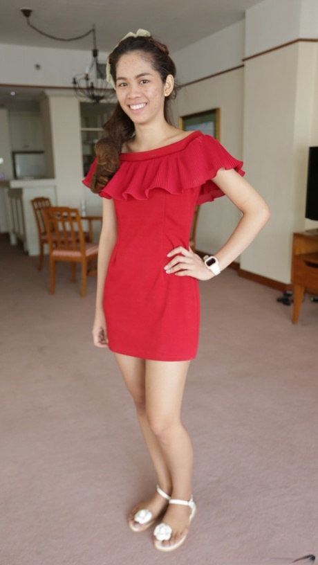 An attractive first-time Thai model poses in her red dress before her modeling gigs.