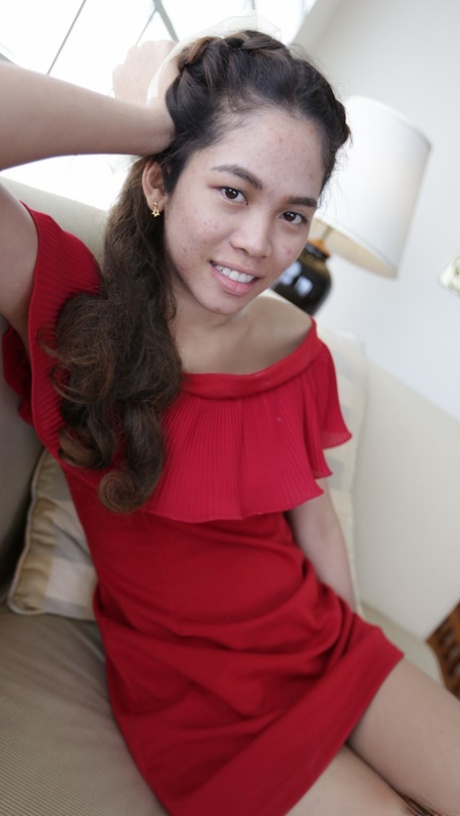 Before her modeling gigs, a first-time Thai model stands in a cute red dress.