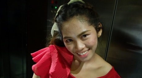 This cute young woman from Thailand models for a living in her red dress before hitting the road.