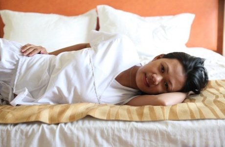 The lusty Filipino nurses, Joanna and Joy, pose for a picture on the bed wearing white uniforms.