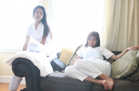 On the bed, Joanna and Joy pose in white uniforms as nurses who are lusty Filipino.