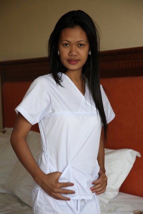 Joanna and Joy, who are nurses in a lusty Filipino outfit, pose for a picture on the bed wearing white uniforms.