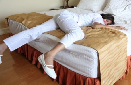 White uniformed nurses Joanna and Joy, who are lusty Filipinos in disguise, take a photo on the bed.