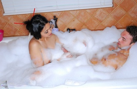 Japanese massage therapist Mika Tan gives a soapy handjob while in front of the bubble bath with her hands on her body.