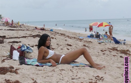 Красивая молодая негритянка Нина Белль с большими сиськами загорает на пляже в бикини