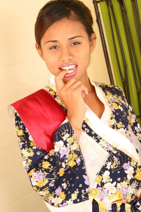 A young Asian male in a colorful blouse teases a small pecker while walking alone.