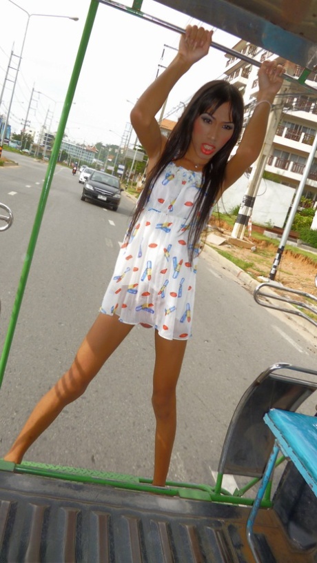 A long-haired Asian man exhibits a small penis on a parade through public areas.